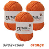 Three skeins of orange Milk cot skin-friendly yarn for knitting and crochet projects