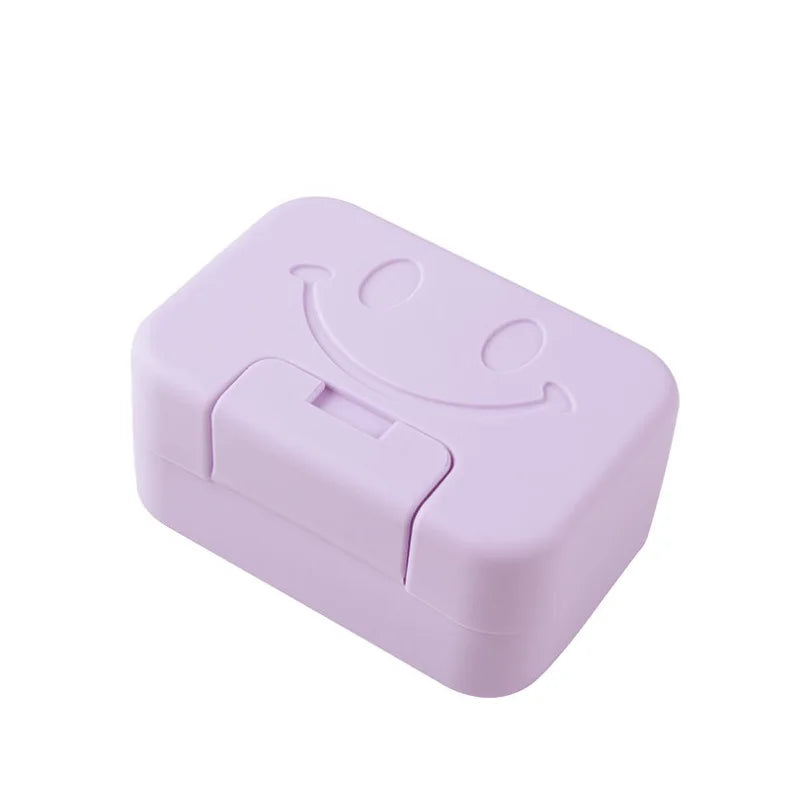 A pink smiley face lidded soap dish for bathroom and travel.