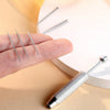 A hand holds a stainless steel piercing ball grabber tool kit with several long, thin metal tools.