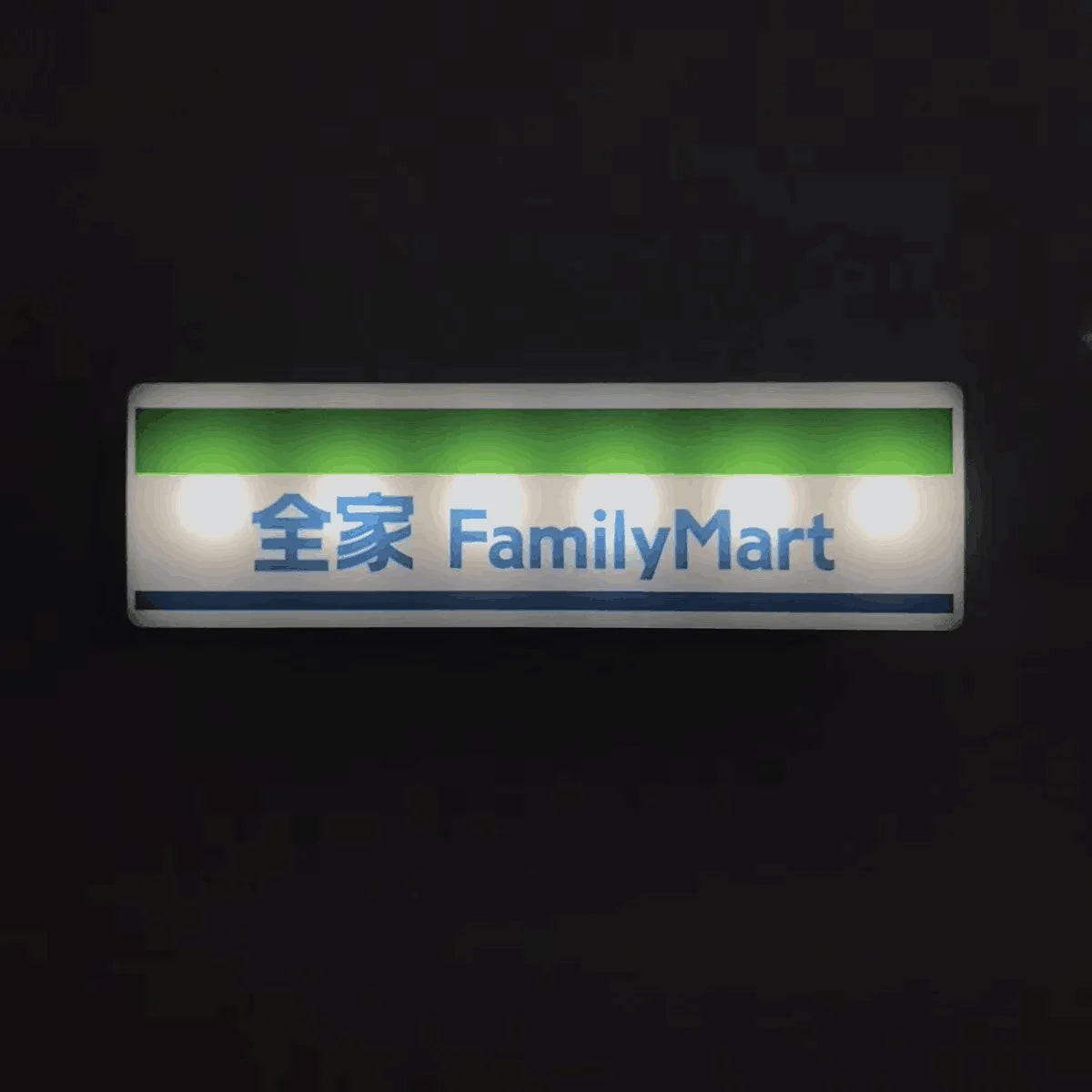 A rectangular glowing magnet featuring the text 全家 FamilyMart on a green background.