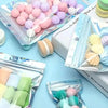 Assortment of colorful self-sealing bags filled with various pastel and holographic candies and treats.