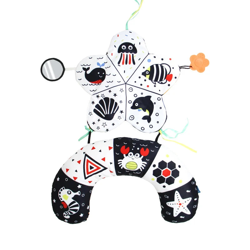 A high contrast tummy time pillow for babies featuring various animal and sea life shapes.
