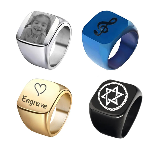 A set of four square rings in silver, blue, gold, and black, showcasing different finishes and engravings.
