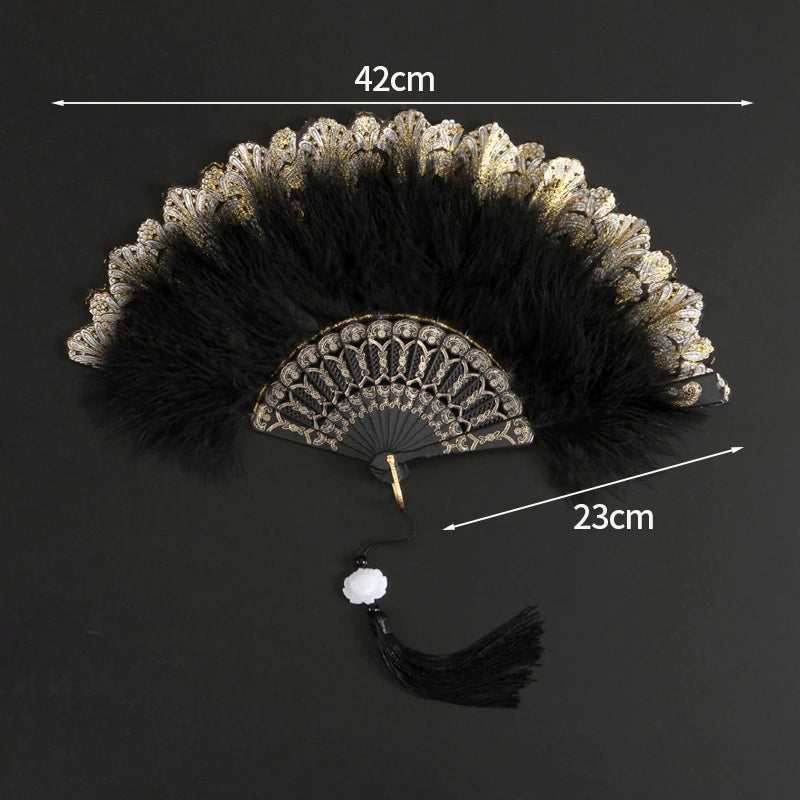 A vintage lace folding hand fan with a black and gold feathered design shown against a dark background.