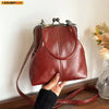 A brown PU leather crossbody handbag with a silver clasp and leather strap is being held by a hand.