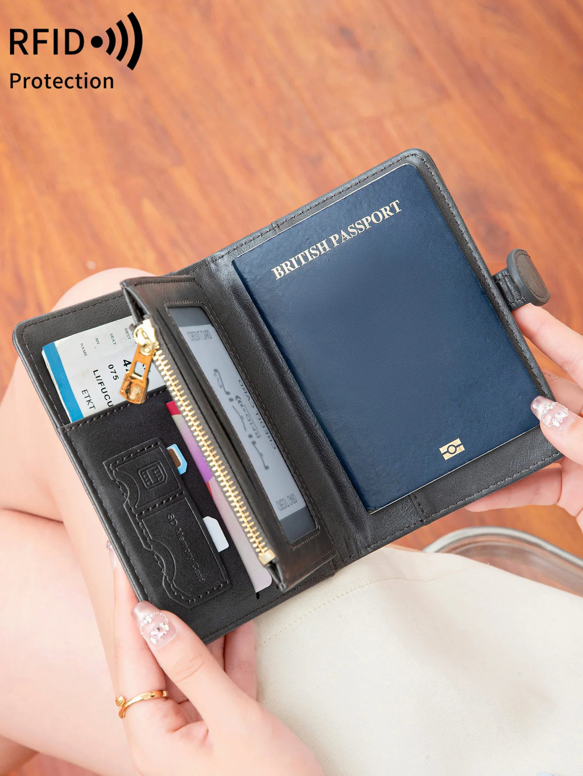 A hand holds an open black passport wallet featuring RFID protection and multiple card slots.
