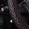Close-up of a black quilted steering wheel cover with red stitching and controls visible.