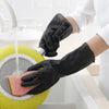 A hand wearing a black rubber cleaning glove is using it to clean a textured pink object in a yellow basin.