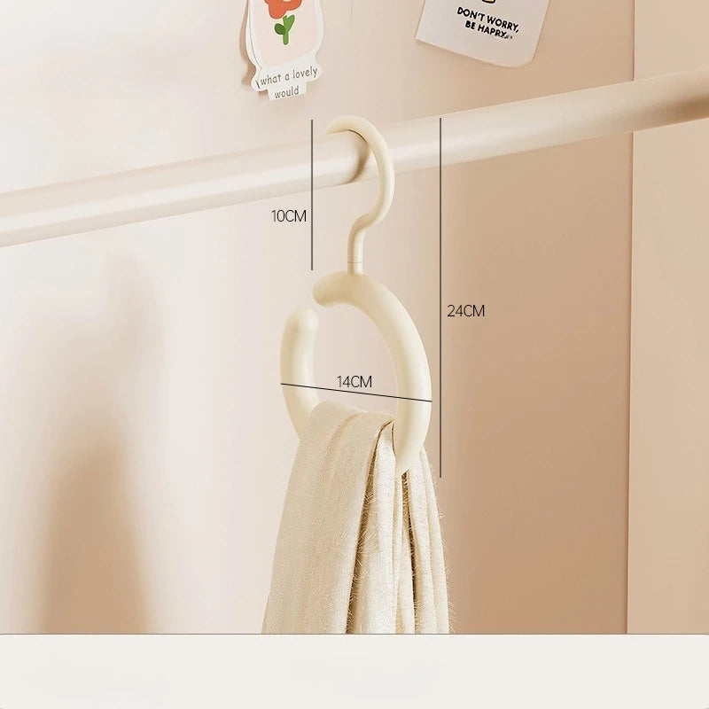 A white wall-mounted hook organizer for hats and scarves is shown hanging on a wooden railing.