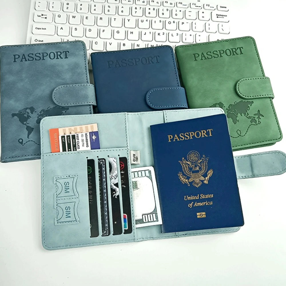 Porta-pasaporte verde azulado con cubierta de cuero y ranuras para documentos, junto a un teclado de portátil.
