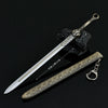 A detailed metal sword with a decorative hilt and a textured blade is displayed next to its keychain.
