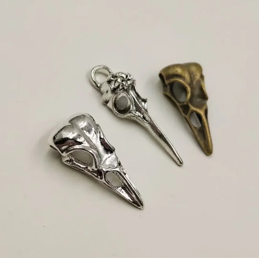 A set of five gothic skull and crow head charms for jewelry making, featuring silver and brass finishes.