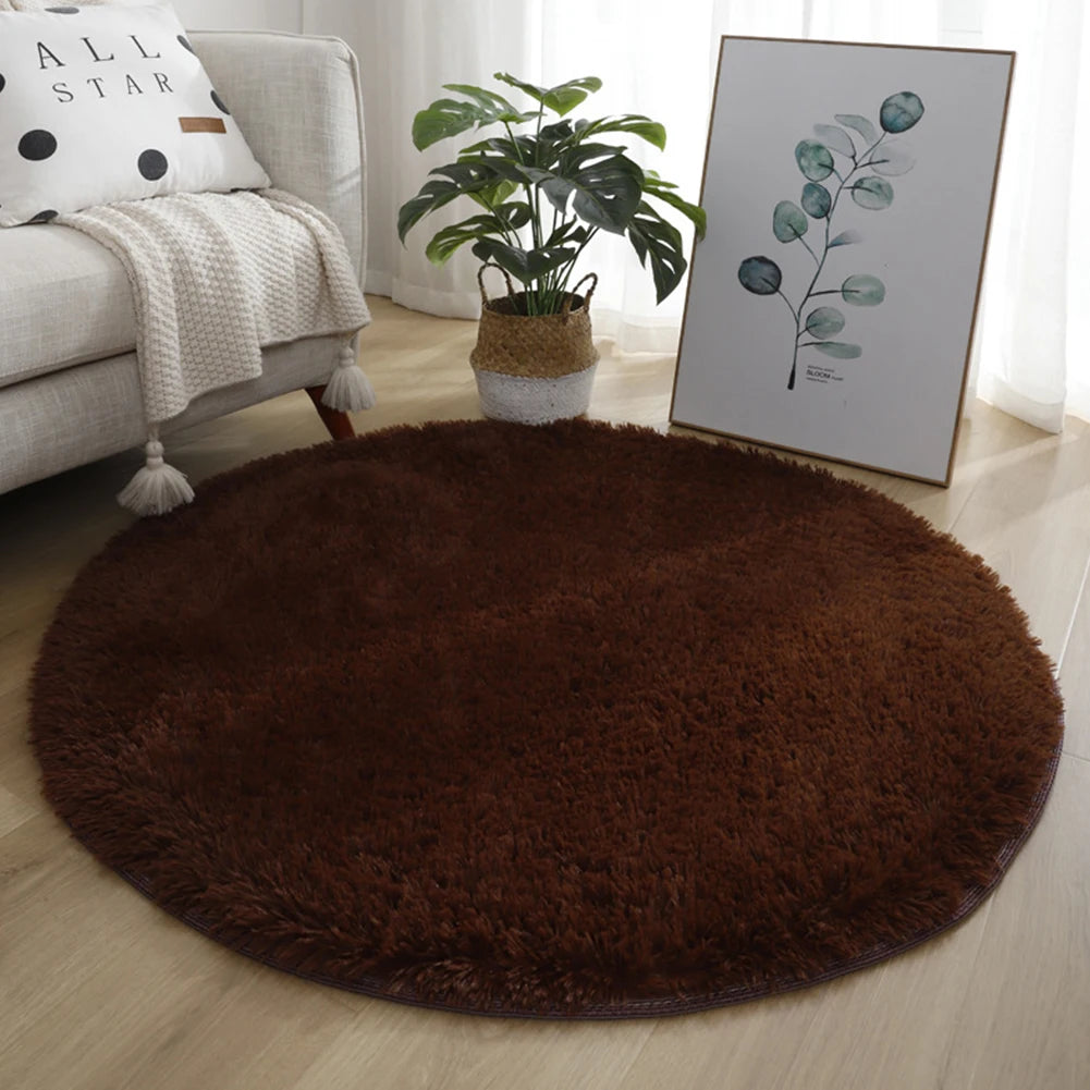 A round, dark brown shaggy rug placed on a light wooden floor.