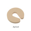 A beige foam door stopper with a curved shape designed for finger pinch protection.