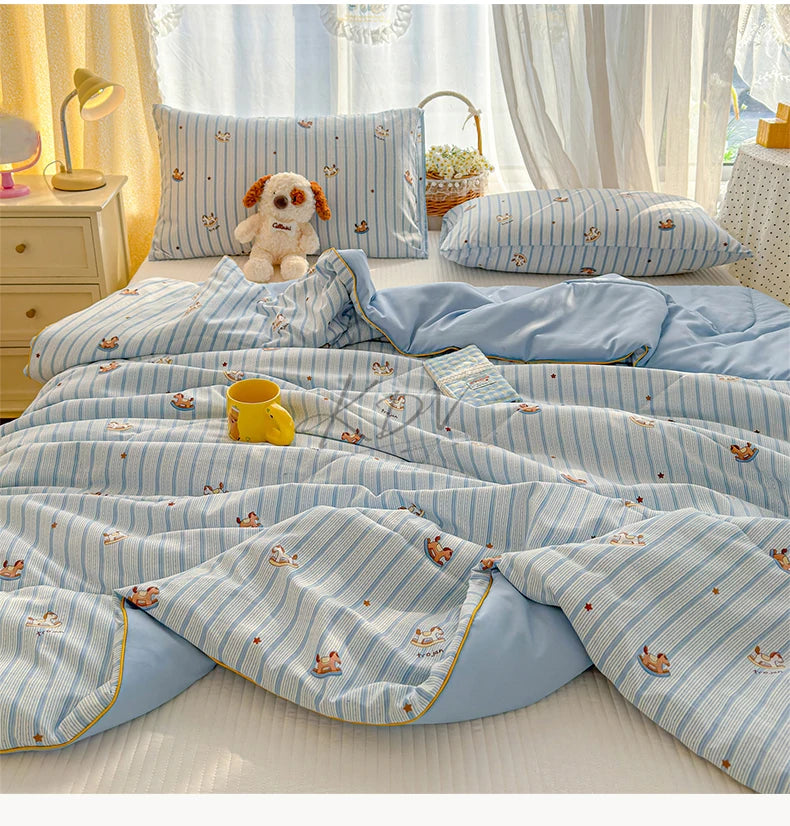 Light blue and white striped quilt with playful cartoon animal prints on a bed