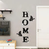 A set of six butterfly-shaped acrylic wall stickers spelling out HOME on a light gray wall.
