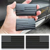 A hand holds a set of matte black 3D American flag car emblems featuring stars and stripes.