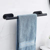 A blue towel hanging on a black stainless steel bar mounted on a white wall.