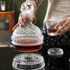 A person is pouring wine from a handcrafted crystal decanter into a glass, with a crystal aerator resting below.