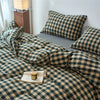 A plaid duvet cover in olive green and beige tones with a checkered pattern is displayed on a bed.