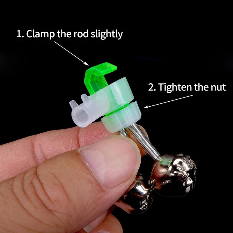 A hand is clamping a green clip-on indicator onto a metal object, demonstrating how to tighten the nut for fishing rod bite a