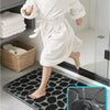 A child wearing a white plush non-slip absorbent bathroom rug with pebble texture on a black mat.