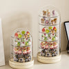 A clear rotating display case holds various small collectible figures and keepsakes.