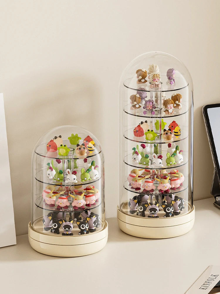 A clear rotating display case holds various small collectible figures and keepsakes.