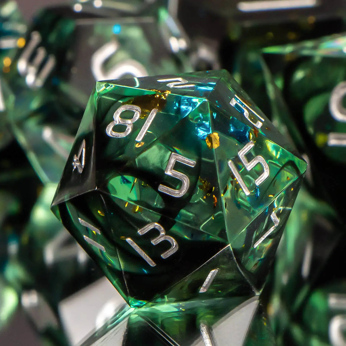 A close-up of a green resin polyhedral dice set, showing various dice faces and reflections.