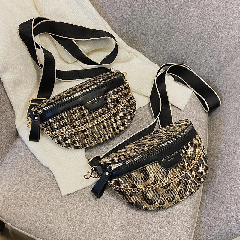 Leopardenmuster-Crossbodytasche mit schwarzen Riemen auf hellem grauem Stoff.
