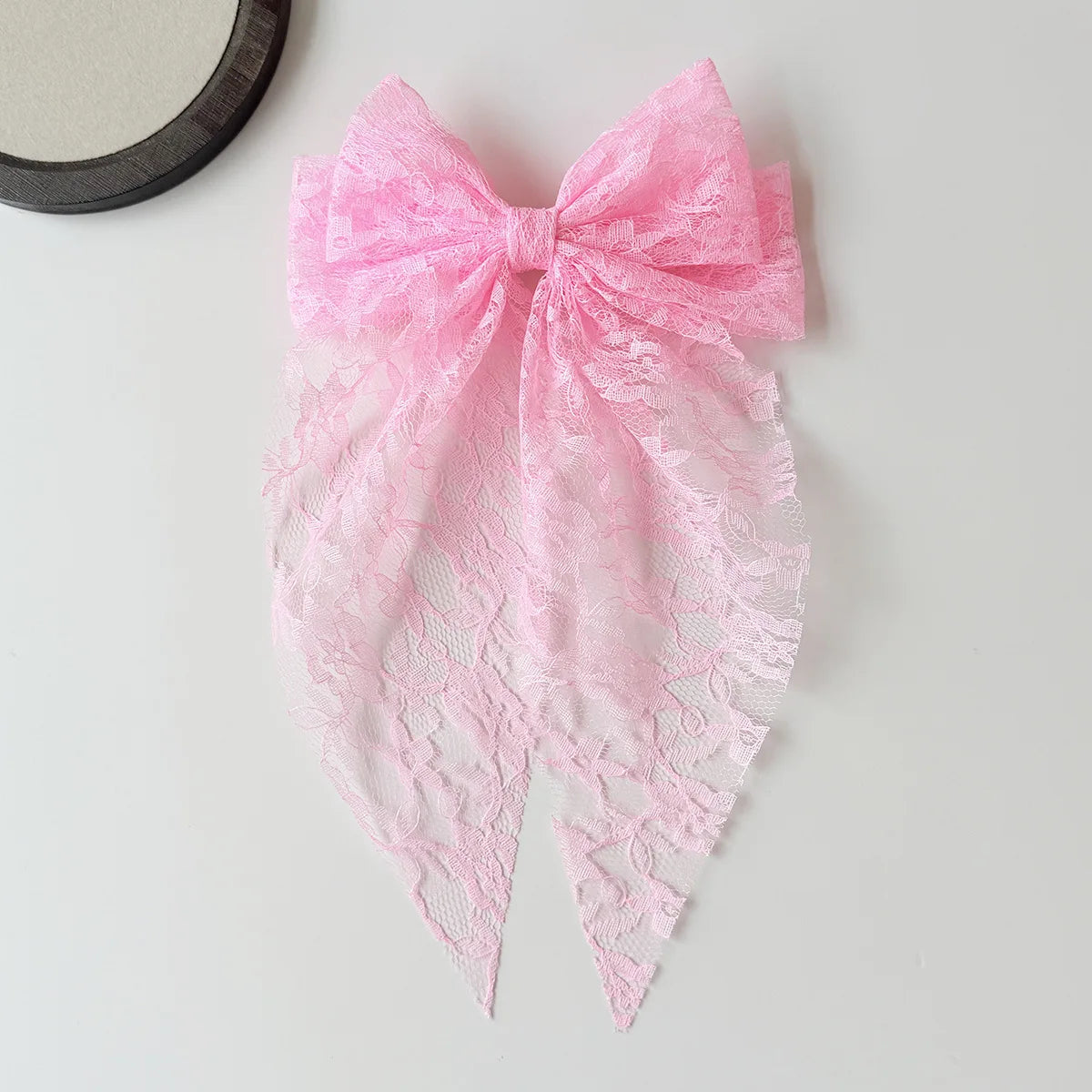 Pink lace bow hair clip for women with a delicate floral pattern