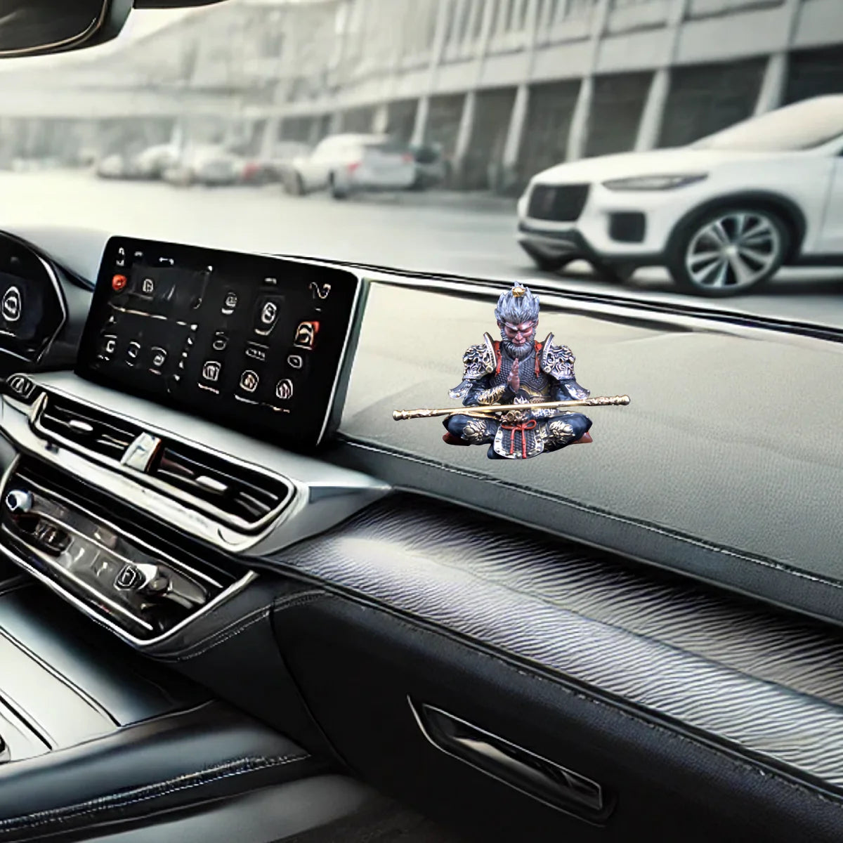 A hand-painted Monkey King figurine with a staff displayed on a car's interior dashboard.