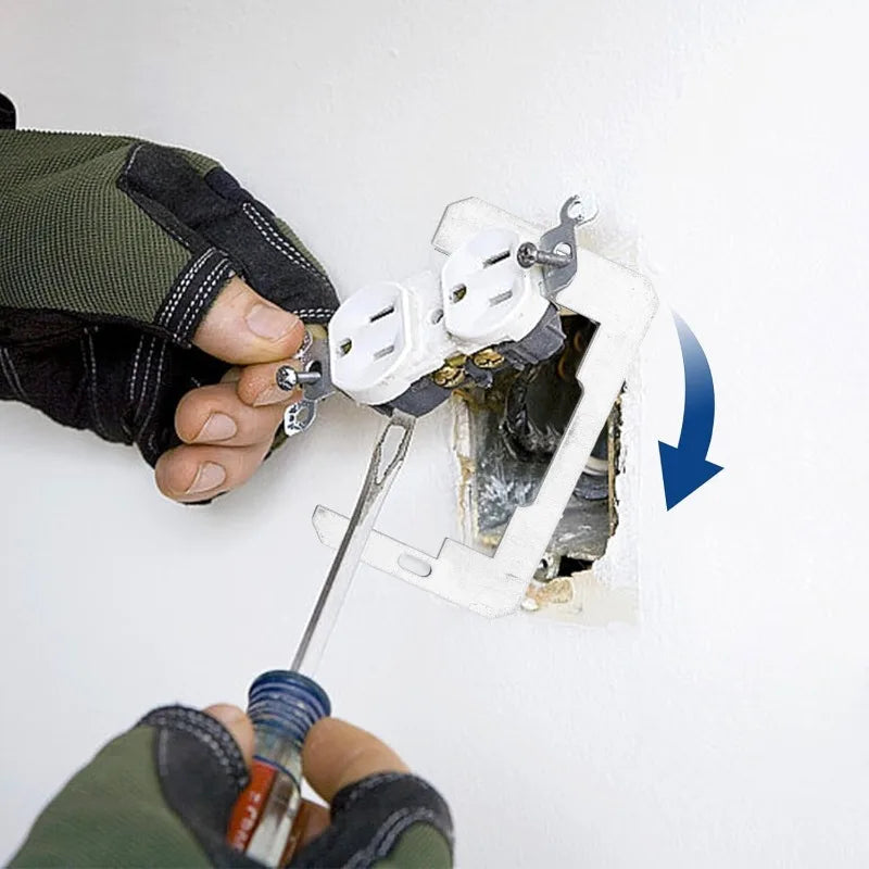 A hand is installing a rust-proof galvanized outlet spacer kit into a flush mount electrical outlet box.