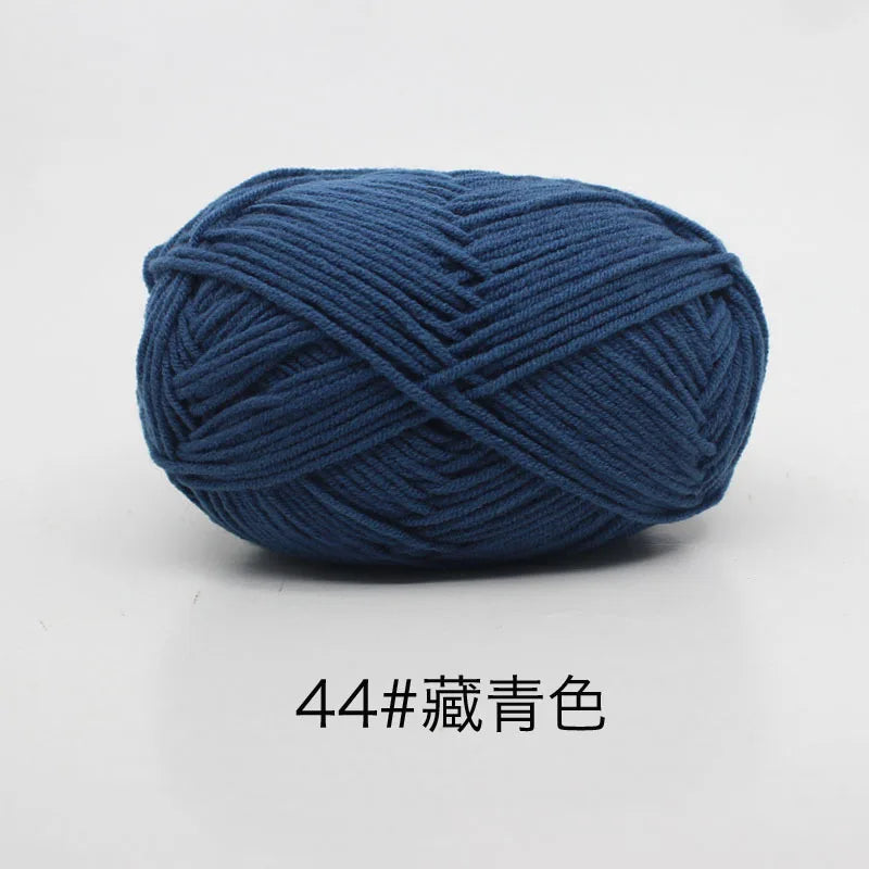 A ball of dark blue 4-ply milk cotton yarn for knitting and crochet.