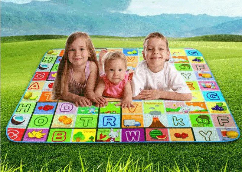 Three children sitting on a colorful soft foam baby play mat outdoors