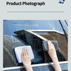 Hands wipe a car window with a white microfiber cloth to clean and remove water spots.