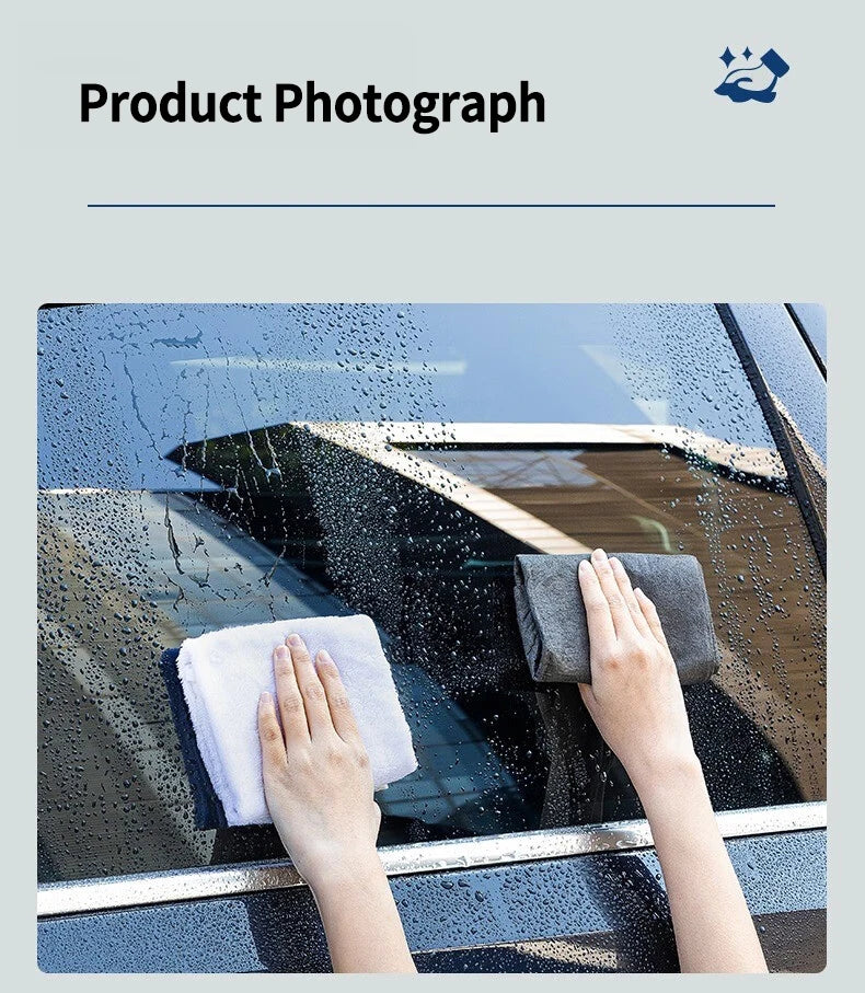 Hands wipe a car window with a white microfiber cloth to clean and remove water spots.