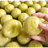 A close-up of yellow potato-shaped squishy toys with black dots, held in a hand.