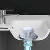 A silver faucet is mounted above a white sink basin with a silicone drain hair catcher visible below.