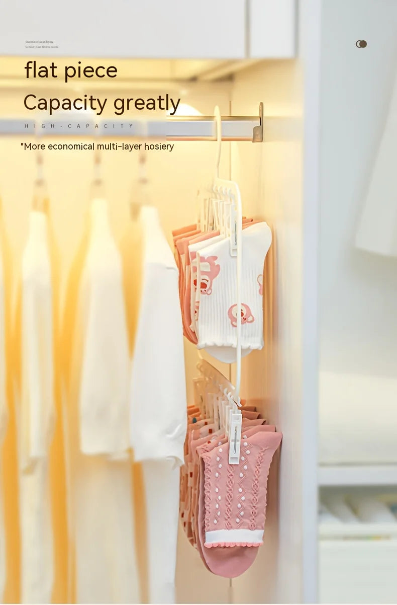 A close-up of a flat piece capacity laundry drying rack with white and pink garments hanging inside a cabinet.