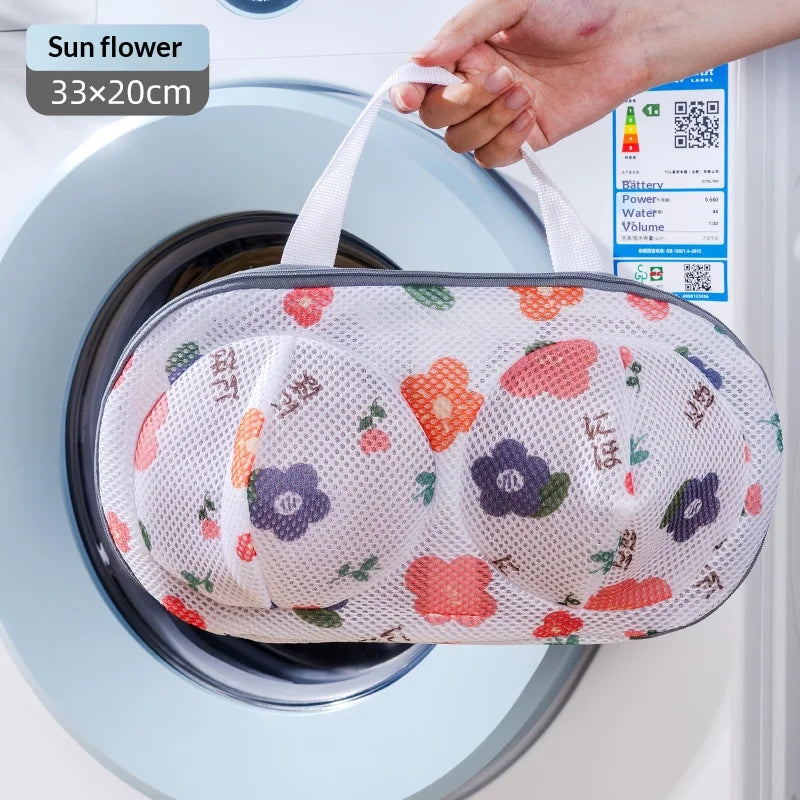 A white mesh laundry bag with a floral pattern is being placed inside a washing machine drum.