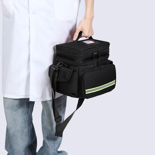 A person holds a black waterproof double-layer trauma and first aid bag for emergency medical supplies.