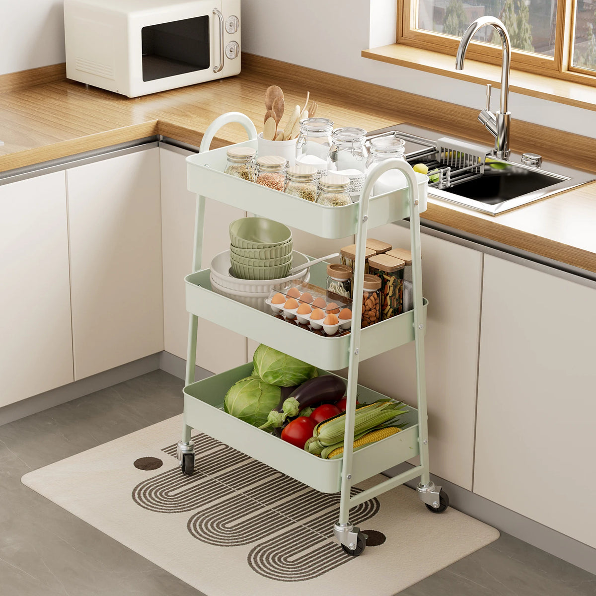 A white 3-tier rolling metal storage cart filled with fresh vegetables and kitchen items on a countertop.