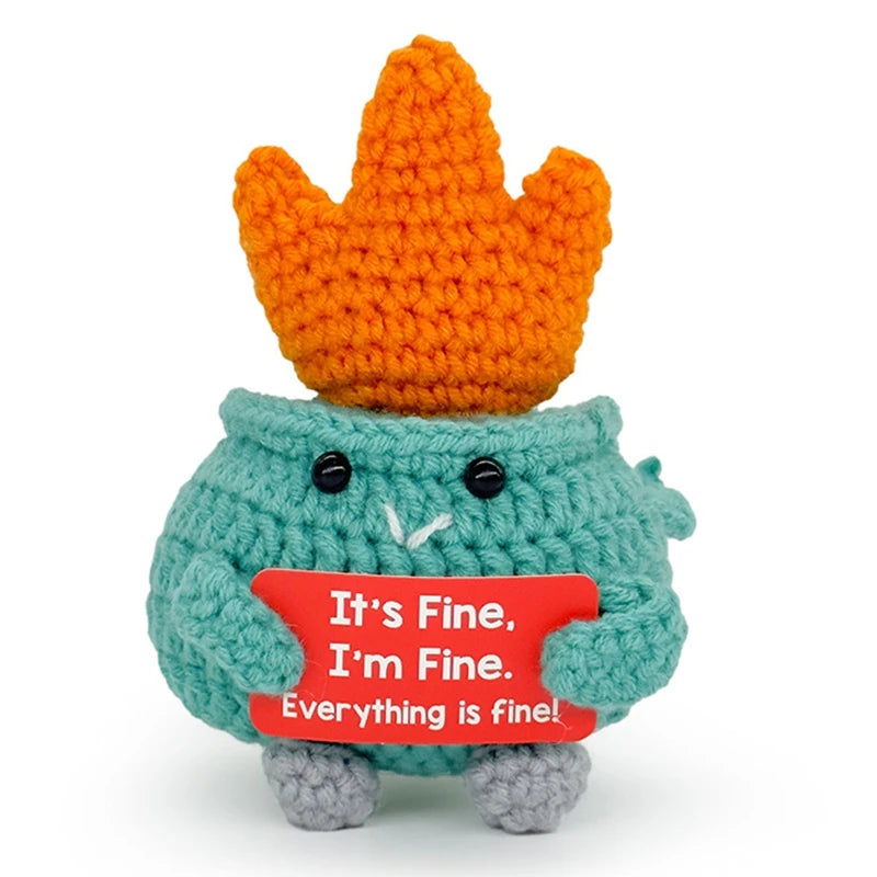 Handmade crochet animal doll in teal with a crown and a red card that says It's Fine I'm Fine Everything is fine
