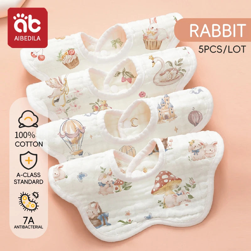 A set of five white cotton muslin bandana bibs featuring rabbit and animal designs for babies