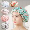 A woman is wearing a floral patterned reusable waterproof shower cap for hair care, with several variations shown nearby.