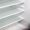 A close-up view of a white, textured refrigerator liner mat with multiple shelves installed inside a cabinet.