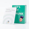 A green box for the Let's Get Drunk card game featuring a humorous illustration of a person with a purple hat.