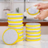 A stack of yellow and white double-sided microfiber cleaning cloths is shown with a hand preparing to use one.