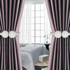 Close-up of pearl magnetic curtain tiebacks in silver and pink on a purple drape.